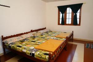 - un lit dans une chambre avec 2 tables dans l'établissement Bison Valley Estate, à Valparai