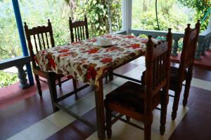 a dining room table with a tablecloth on a table with chairs at Bison Valley Estate in Vālpārai
