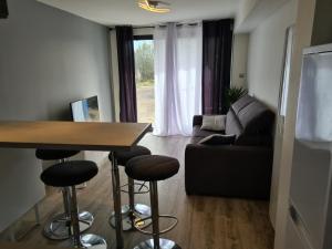 a living room with a table and a couch at spacieux studio dans le Beaujolais in Saint-Georges-de-Reneins