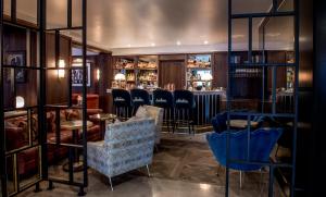 倫敦的住宿－馬里波恩酒店，一间酒吧,房间内设有蓝色的椅子和桌子