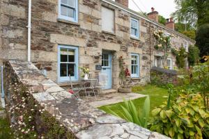 a stone house with a garden in front of it at Navas Nook in Falmouth