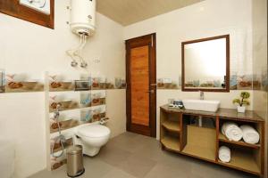 a bathroom with a toilet and a sink and a mirror at Snow Bloom Resort in Manāli +21 photos