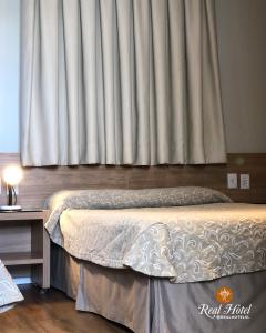 塞蒂拉瓜斯的住宿－Real Hotel，一间卧室设有一张床和一个大窗户