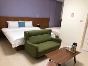 a bedroom with a bed and a green chair at Bear Baby Homestay in Jinning +11 photos