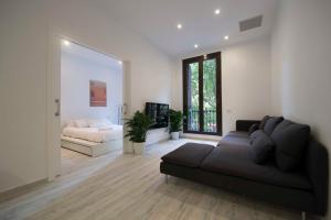 sala de estar con sofá y cama en Roger De Lluria Design Apartment, en Barcelona