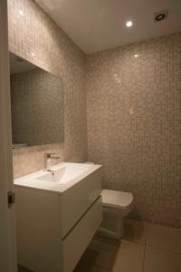 y baño con lavabo, aseo y espejo. en Roger De Lluria Design Apartment, en Barcelona