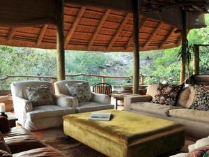 Sala de estar con sofás y mesa de centro en Buffalo Ridge Safari Lodge, en Reserva de Madikwe