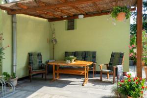 Une table et des chaises en bois sont disponibles sur la terrasse. dans l'établissement Wellness penzion U Grygarů, à Lipník nad Bečvou