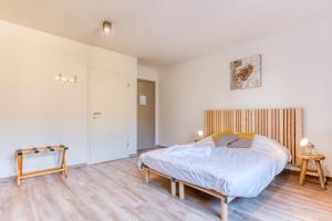 ein Schlafzimmer mit einem großen Bett und Holzboden in der Unterkunft Gîte de la cascade in Villers-devant-Orval