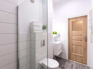a bathroom with a toilet and a glass shower at VacationClub - Willa Carmen Apartment 3 in Świnoujście +10 photos