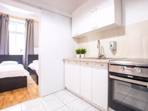 a white kitchen with a sink and a stove at VacationClub - Willa Carmen Apartment 3 in Świnoujście