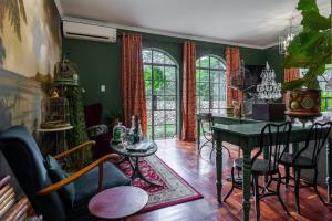 a living room with green walls and a table and chairs at Festina Lente Guesthouse in Johannesburg