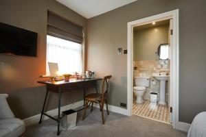 a bathroom with a desk and a sink and a toilet at The Quarrymans Arms in Corsham