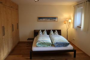 een bed met kussens in een kamer bij Ferienwohnung Heer in Marquartstein