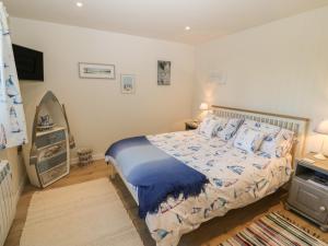 a bedroom with a bed and a television in it at The Sail Loft in Pwllheli