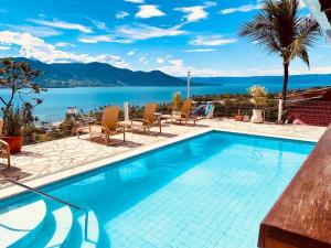 a swimming pool with a view of the water at Hotel Vista Bella in Ilhabela