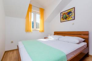 a bedroom with a bed and a window at Apartments Villa Perla in Dubrovnik
