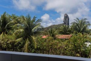 a view of a resort with a rock in the background at Villa Noronha Hostel e Suites in Fernando de Noronha