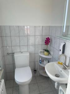 a white bathroom with a toilet and a sink at Appartement Seebadallee mit Wallbox für e-Autos in Rangsdorf