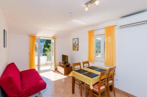 sala de estar con sofá rojo y mesa en Apartments Villa Perla, en Dubrovnik