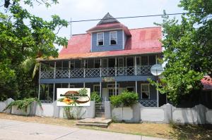 een blauw huis met een rood dak bij Coconut Paradise Lodge in San Andrés