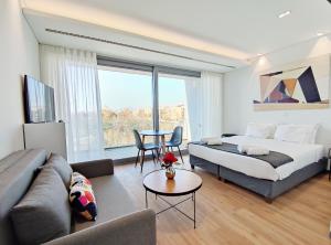 a bedroom with a bed and a couch and a table at Verde Apartments in Athens