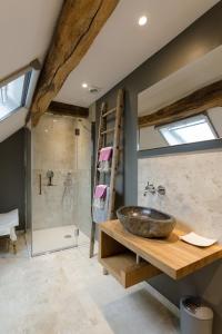 a bathroom with a stone sink and a shower at G'Ardenne Blue in Durbuy