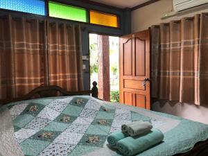 a bedroom with a bed and a window at Ruen Thai Ban Rim Nam in Kamphaeng Phet