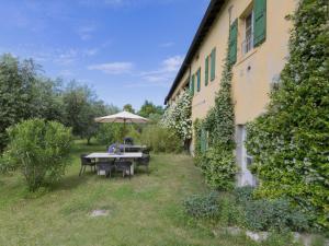 a table with an umbrella next to a building at Apartment Tenuta Naiano Raffaello in Cavaion Veronese +7 photos