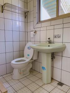 a bathroom with a toilet and a sink at Youlin Homestay in Meishan