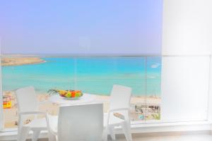 a dining room table and chairs with a view of the ocean at Vassos Nissi Plage Hotel & Spa in Ayia Napa