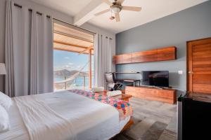 a bedroom with a bed and a desk and a television at Casa ChaChaCha in San Juan del Sur
