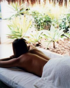 a woman laying on a bed in a room at UXUA Casa Hotel & Spa in Trancoso
