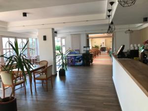 a dining room with a bar and tables and chairs at Zsanett Hotel in Balatonkeresztúr