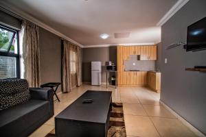 a living room with a couch and a table at Khayalami Hotel - Standerton in Standerton