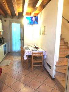 a kitchen and dining room with a table and a tv at Appartamenti Esmera in Desenzano del Garda