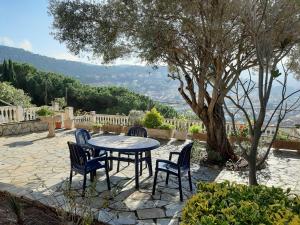 eine Terrasse mit einem Tisch, Stühlen und einem Baum in der Unterkunft Habitaciones en Villa Coliving Casa Rural in San Fausto de Campcentellas