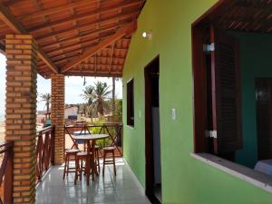 a room with a table and chairs on a balcony at Chalé da Kikia in Icapuí