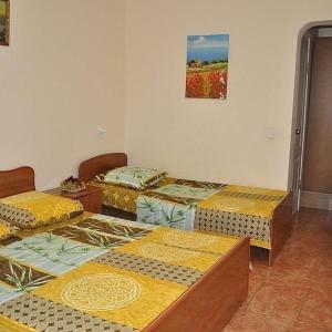 アナパにあるGuest House Arinaの黄色と緑の毛布が備わる客室のベッド3台