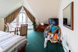 um quarto com uma cama e uma mesa com uma cadeira em Zsanett Hotel em Balatonkeresztúr