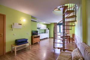 a living room with a spiral staircase and a kitchen at Apartamentos Barajas in Madrid