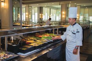 a chef standing in front of a buffet at Riu Palace Aruba - All Inclusive in Palm-Eagle Beach
