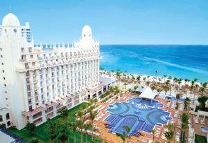 a large white building with a clock on it at Riu Palace Aruba - All Inclusive in Palm-Eagle Beach