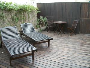 two benches and a table and chairs on a deck at A Hotel in Buenos Aires