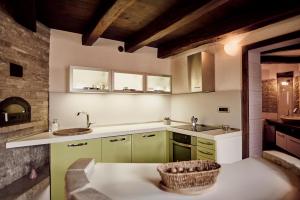 a kitchen with green cabinets and a basket on the counter at Tmbin's barn - nature, horses, family in Sežana +37 photos