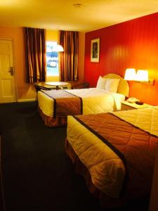 2 camas en una habitación de hotel con paredes rojas en Duffys Motel - Calhoun, en Calhoun