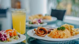 a table with plates of food and a glass of orange juice at Hotel la Ardilla de Santa Fe in Santa Fe de Antioquia