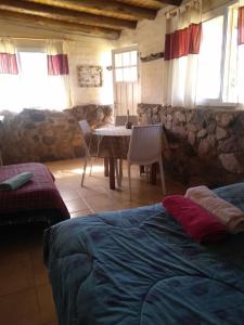 een slaapkamer met een tafel en een stenen muur bij Casa Tai - La Crucecita in Godoy Cruz