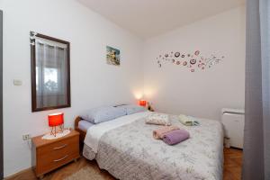 um quarto com 2 camas e uma mesa com um candeeiro em Apartman Pandula em Tkon