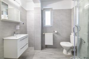 a white bathroom with a toilet and a sink at Hotel Nowa Panorama in Kraków